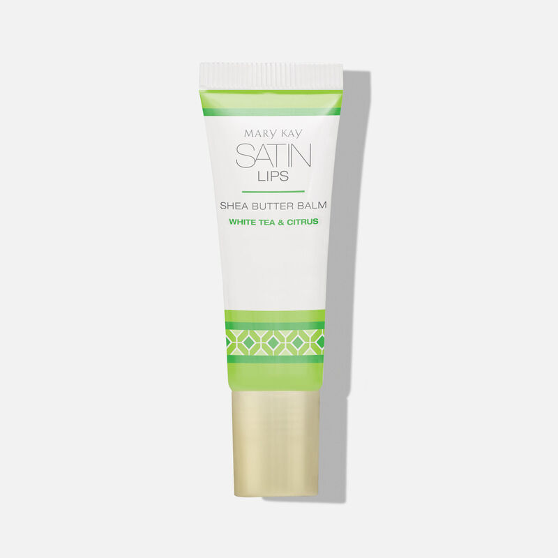 Green and white tube of Satin Lips She Butter balm on plain background