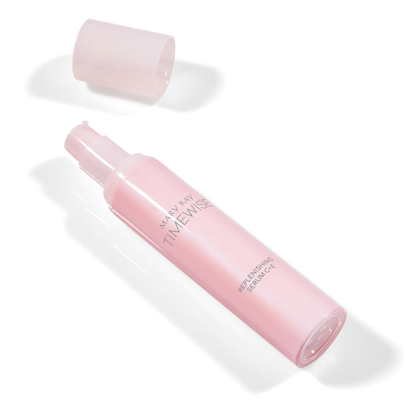 Uncapped bottle of TimeWise Replenishing Serum C+E and cap laying down on plain background