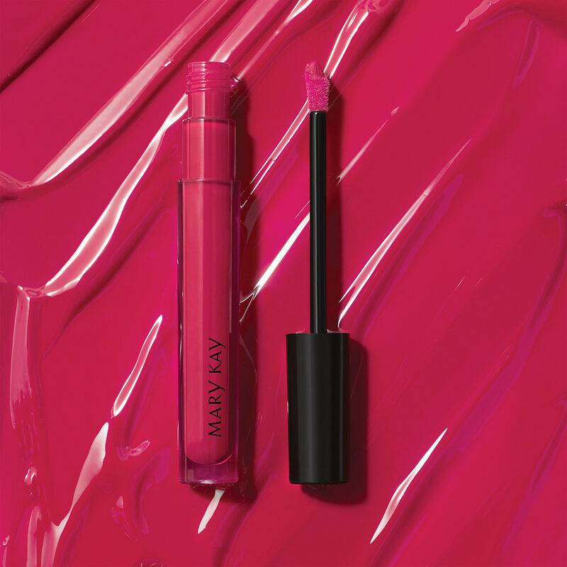Open tube of Mary Kay Unlimited Lip Gloss in shade Pink Fusion against accompanying shade rub.