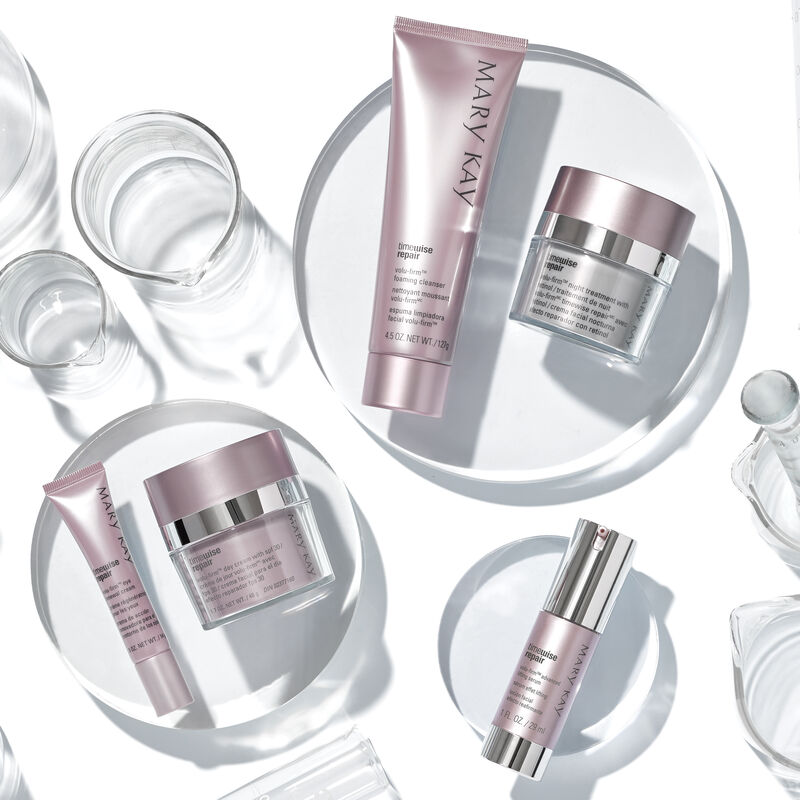 The Mary Kay TimeWise Repair Volu-Firm Set placed on clear platforms with clear scientific accessories.