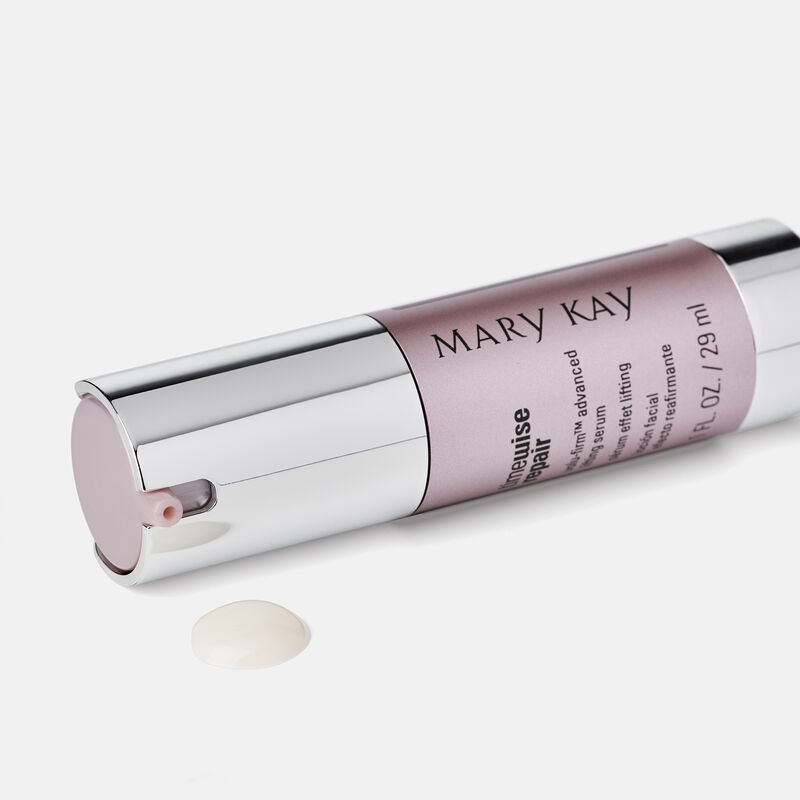 Bottle of TimeWise Repair Volu-Firm Advanced Lifting Serum laying on its side with product drip