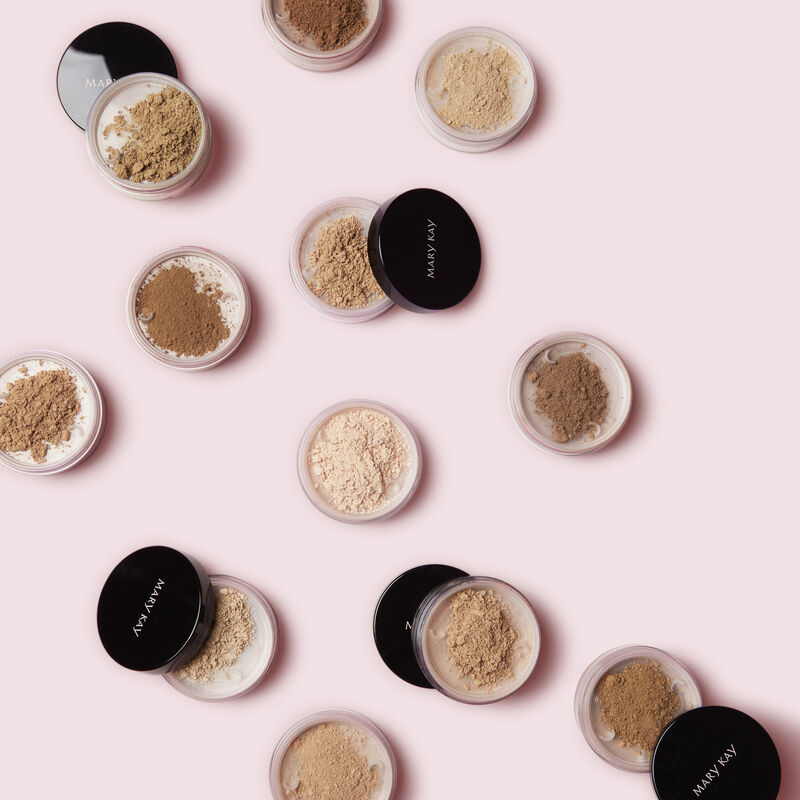Open jars of Mary Kay&reg; Silky Setting Powder against pink background