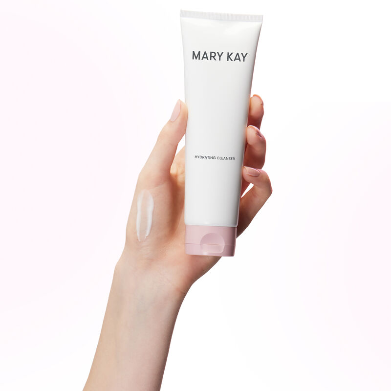 Hand holding tube of Mary Kay Hydrating Cleanser with product rub on the hand