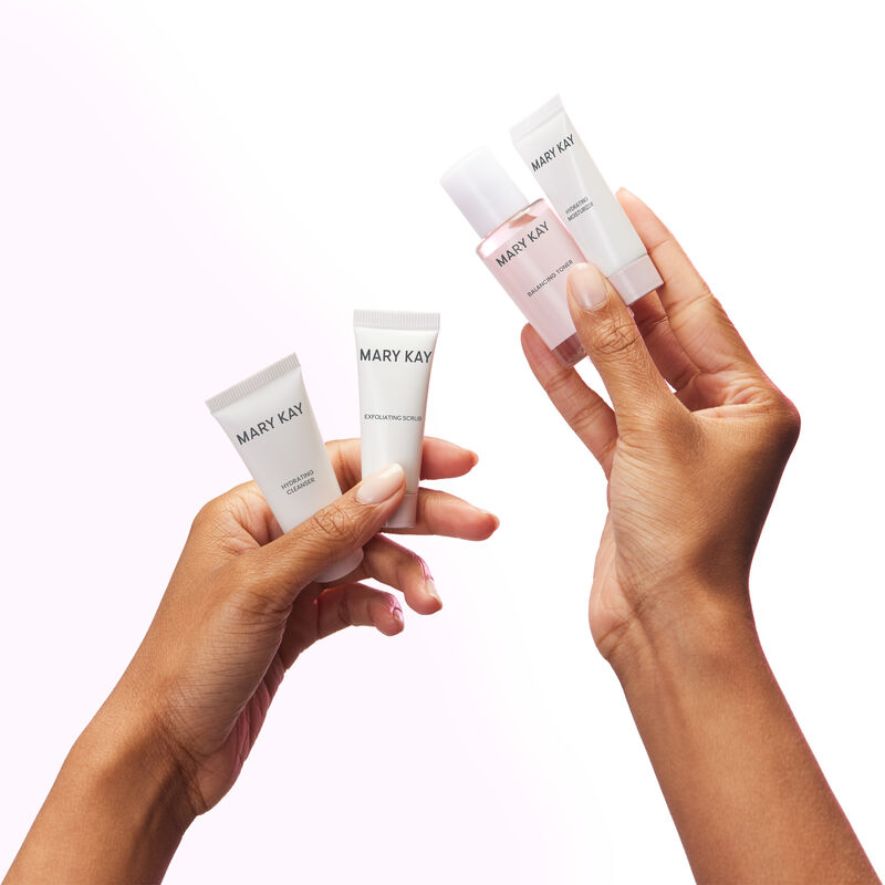 Medium-skinned hands holding miniature bottles of the Mary Kay Hydrating Go Set