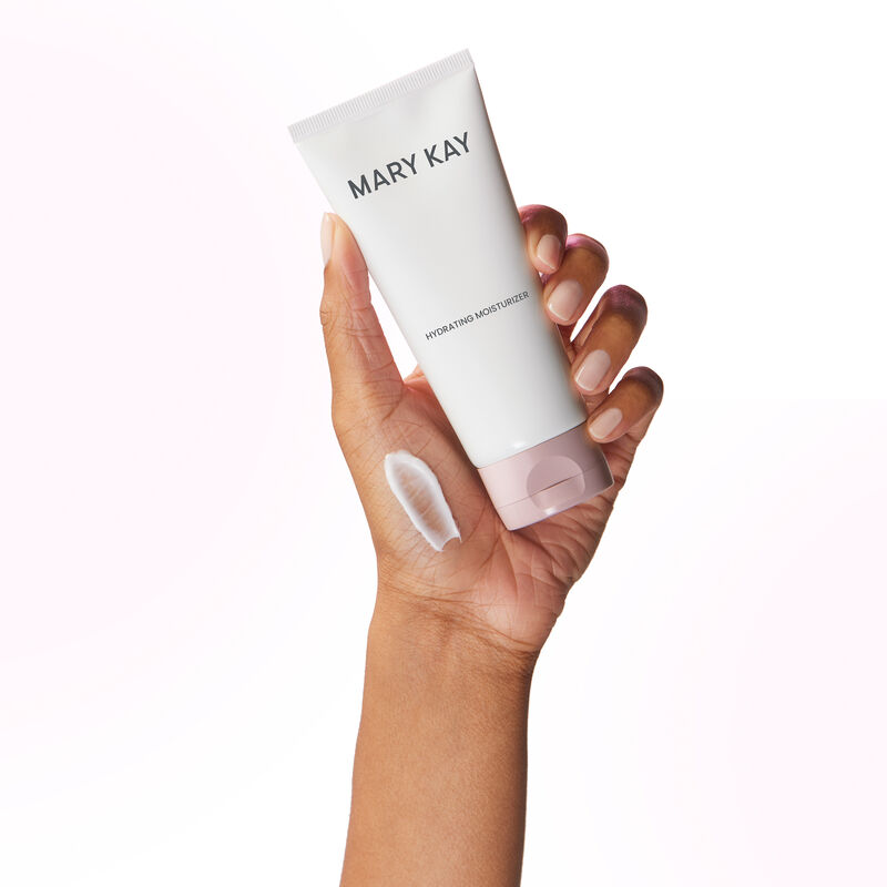 Hand holding tube of Mary Kay Hydrating Moisturizer with product rub on the hand