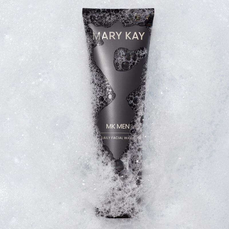 Tube of MKMen Daily Facial Wash immersed in foamy bubbles