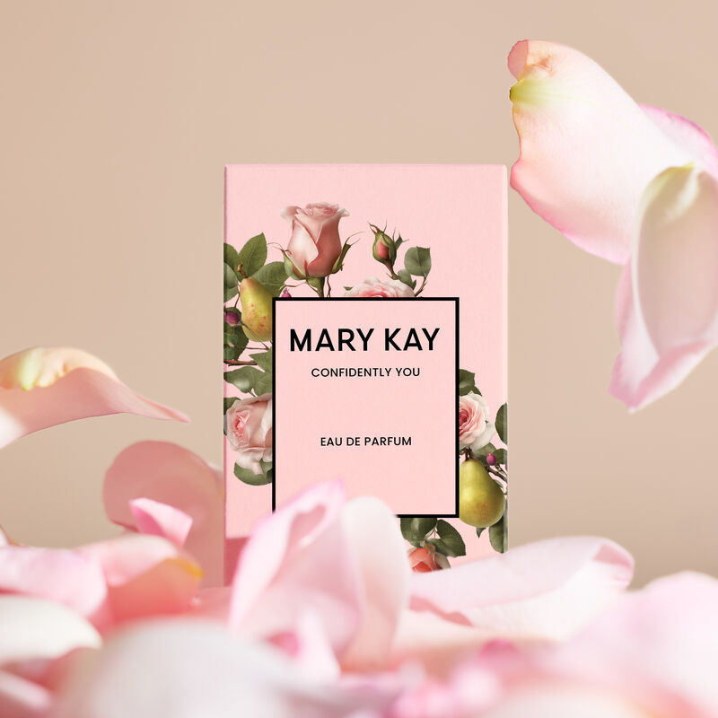 Mary Kay Confidently You Eau de Parfum box with falling rose petals against light pink background