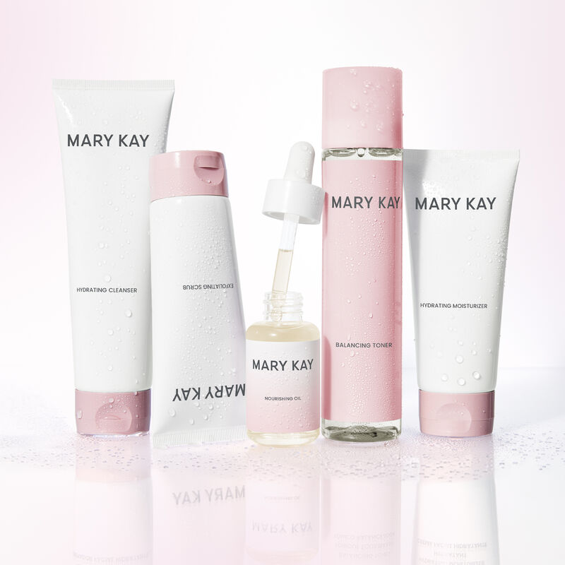 Mary Kay Hydrating Regimen with open bottle of Mary Kay Nourishing Oil standing on reflective surface.