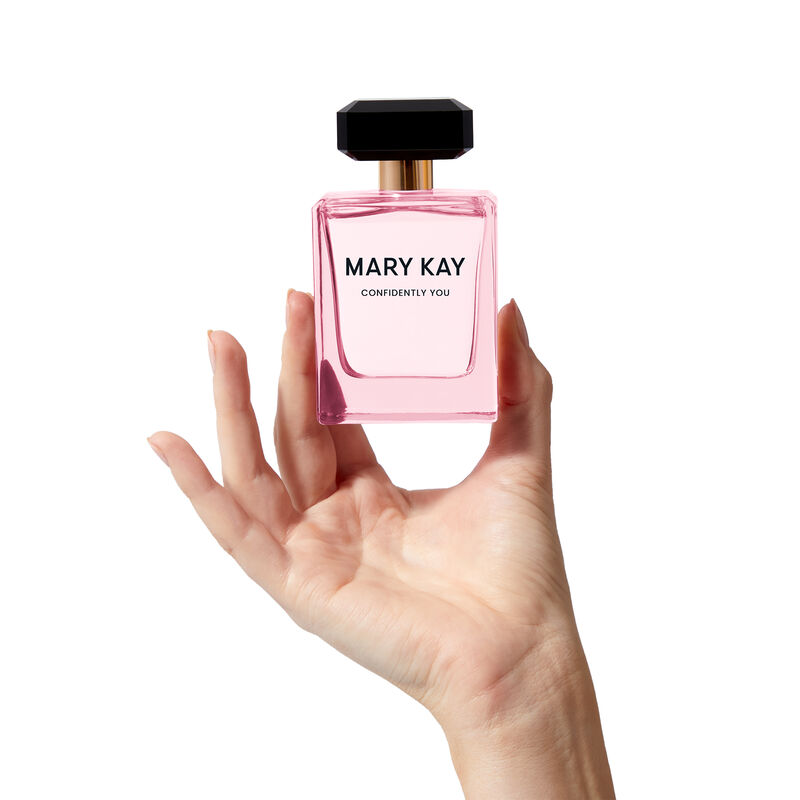 Mary Kay Confidently You bottle held by a fair-skinned hand