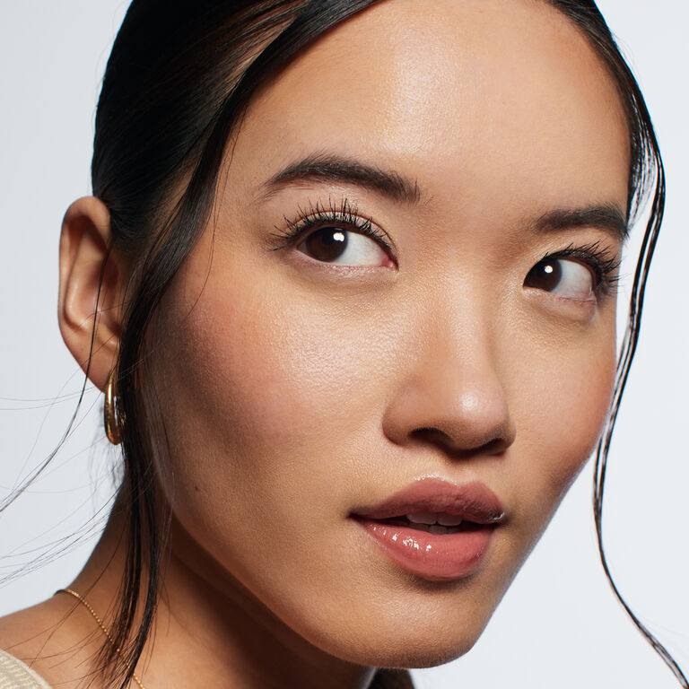 Close-up of brunette model with nude glossy lips looking upward
