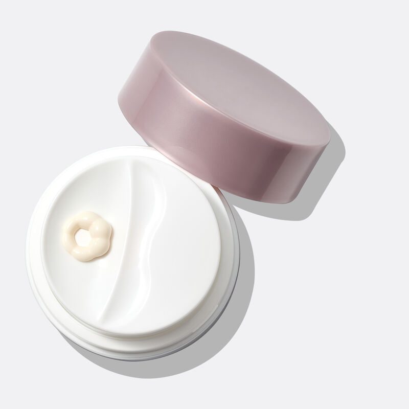 Close-up of Day Cream open jar with product being dispensed.