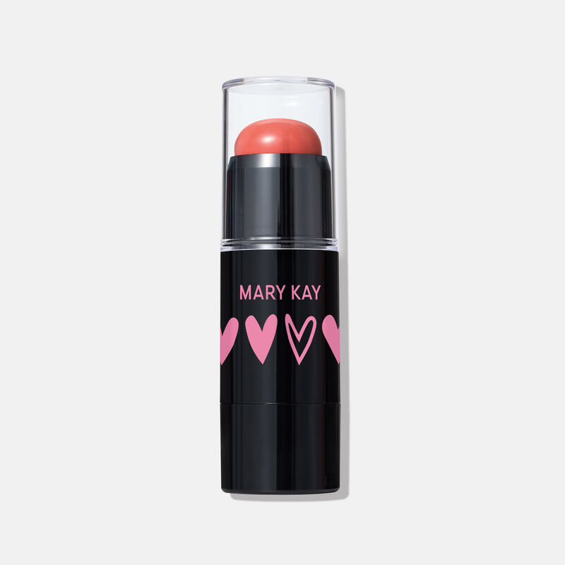 Special-edition Mary Kay Blush Stick in shade Kind Spirit, a coral cream blush in a sleek black tube with pink heart designs and a clear cap.