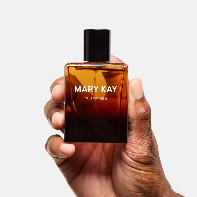 Deep-skinned hand holding Mary Kay True Optimism Eau de Parfum