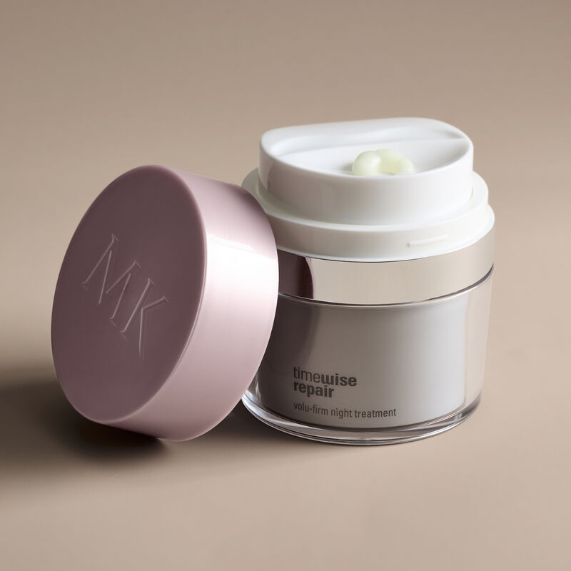 Close-up shot of Night Treatment with cap off against beige background with shadows.