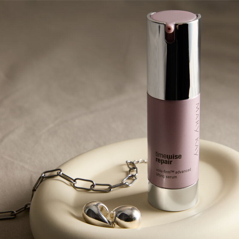Advanced Lifting Serum standing in a dish with a silver bracelet and earrings.